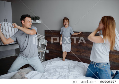 young caucasian family fighting with pillows young caucasian family fighting with pillows 60596357