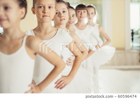 group of little caucasian ballerinas stand in row and practice ballet 60596474