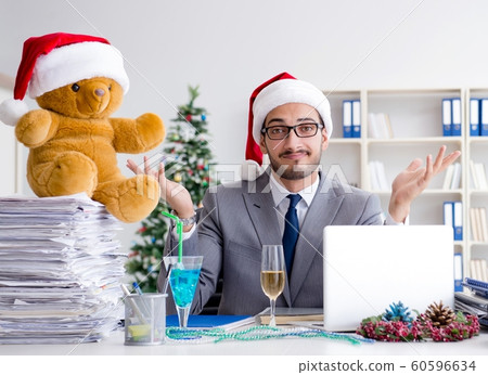 Young businessman celebrating christmas in the office 60596634