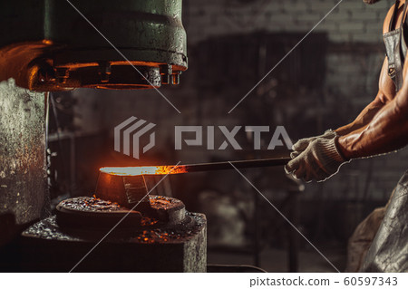young bearded blacksmith heats the metal young bearded blacksmith heats the metal 60597343