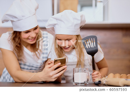 caucasian child and mother happy to bake together caucasian child and mother happy to bake together 60597593