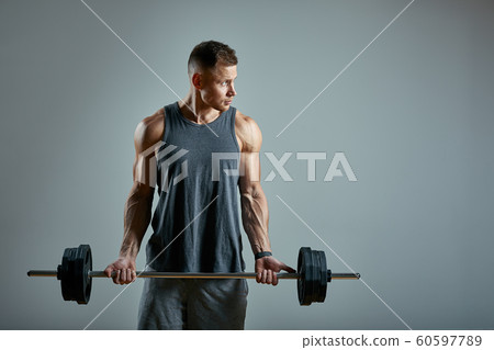 Man doing back workout, barbell row in studio over gray background. Copy space 60597789