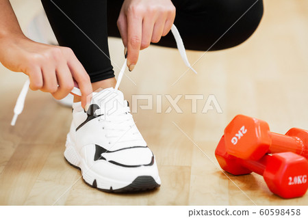 Fitness woman tying sneakers rope. Sportswear and Fashion theme 60598458