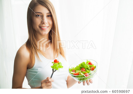 Diet and health.Young woman eating healthy food after workout 60598697