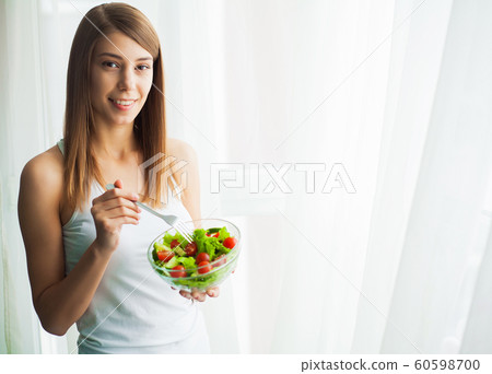 Diet and health. Young woman eating healthy salad after workout Diet and health. Young woman eating healthy salad after workout 60598700