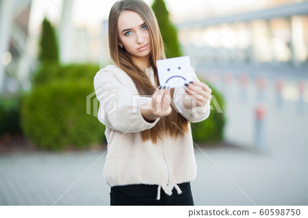 Beautiful woman holding card with sad smile Beautiful woman holding card with sad smile 60598750