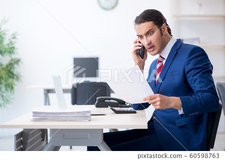 Young male businessman sitting in the office Young male businessman sitting in the office 60598763