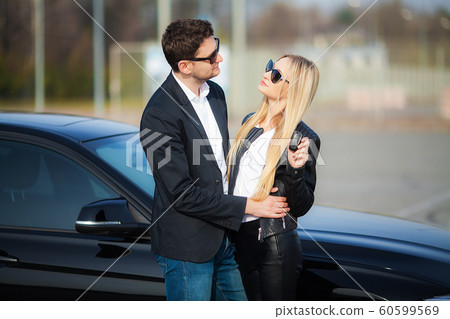 The successful visit to the dealership. Happy young couple chooses and buying a new car for the family The successful visit to the dealership. Happy young couple chooses and buying a new car for the family 60599569