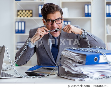Busy employee chained to his office desk 60600050