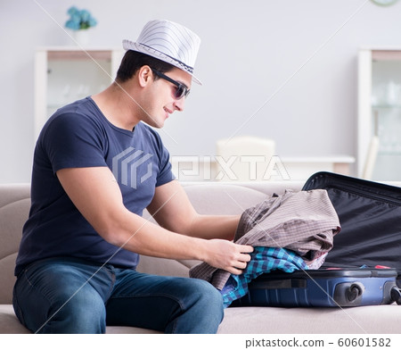 Man with hat preparing for summer vacation Man with hat preparing for summer vacation 60601582