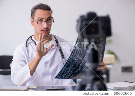 Young male doctor radiologist recording video for his blog 60602660