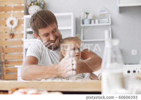 Family sitting in a kitchen and cook the dough for cookies Family sitting in a kitchen and cook the dough for cookies 60606393