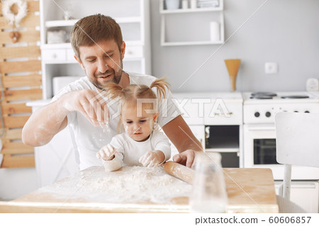 Family sitting in a kitchen and cook the dough for cookies Family sitting in a kitchen and cook the dough for cookies 60606857