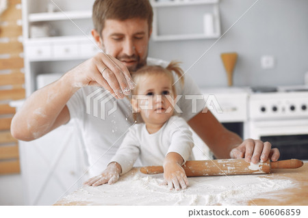 Family sitting in a kitchen and cook the dough for cookies Family sitting in a kitchen and cook the dough for cookies 60606859