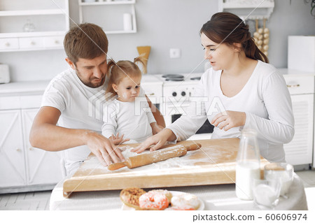 Family sitting in a kitchen and cook the dough for cookies 60606974