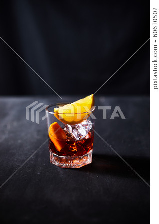 Alcoholic cocktail with orange peel and ice. Alcoholic cocktail with orange peel and ice. 60610502