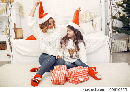Mother with cute daughter sitting in a room Mother with cute daughter sitting in a room 60610755