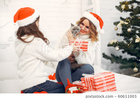 Mother with cute daughter sitting on a bed Mother with cute daughter sitting on a bed 60611003