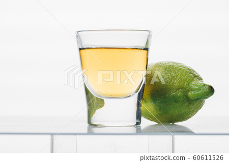 glass with strong alcoholic drink and lemon 60611526