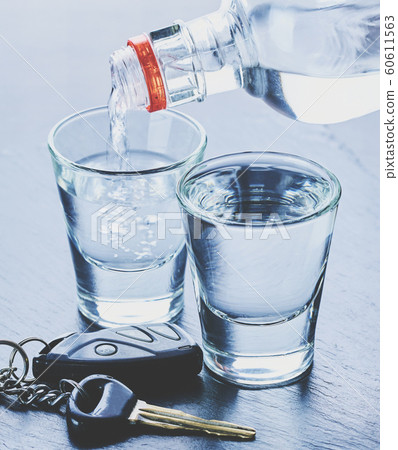 alcohol is poured into glasses and car keys 60611563