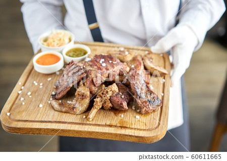 Various grilled meat set with Pickled cabbage and two sauces. Serving on a wooden Board. Barbecue restaurant menu, a series of photos of different meats. Various grilled meat set with Pickled cabbage and two sauces. Serving on a wooden Board. Barbecue restaurant menu, a series of photos of different meats. 60611665