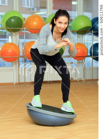Young woman doing fitness exercise with bosu ball Young woman doing fitness exercise with bosu ball 60611766
