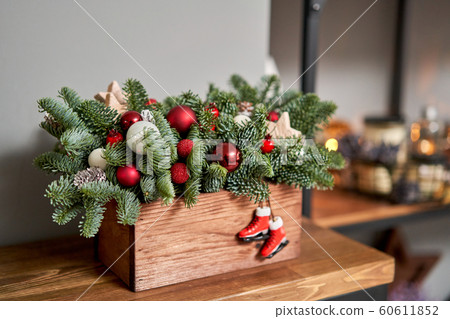 Small arrangement of fresh spruce in a rustic wooden box. Christmas mood. Bokeh of Garland, lamps lights on background. Small arrangement of fresh spruce in a rustic wooden box. Christmas mood. Bokeh of Garland, lamps lights on background. 60611852
