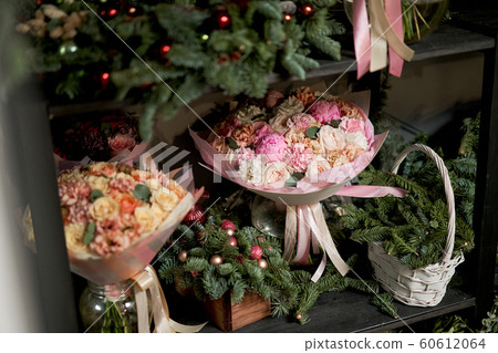 Flower shop concept. Stock of Christmas trees for Christmas compositions.Different varieties fresh spring flowers in refrigerator room for flowers. Bouquets on shelf, florist business Flower shop concept. Stock of Christmas trees for Christmas compositions.Different varieties fresh spring flowers in refrigerator room for flowers. Bouquets on shelf, florist business 60612064