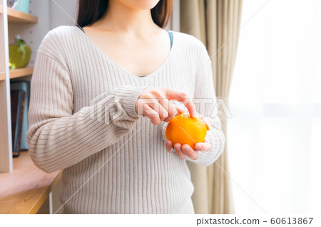 A woman who peels tangerine A woman who peels tangerine 60613867