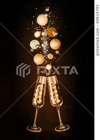 Christmas composition. Glasses with champagne wine from gold festive decorations on a black background with glitters. The concept of a party and a festive feast Christmas composition. Glasses with champagne wine from gold festive decorations on a black background with glitters. The concept of a party and a festive feast 60614793