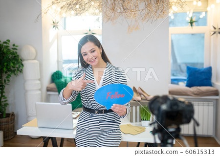 Happy positive woman pointing at the sign 60615313