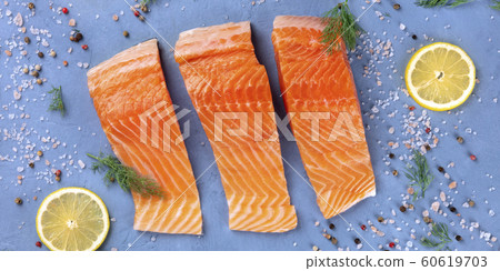 Salmon top-down panorama. Slices of raw fish with lemon, dill, salt and pepper, a culinary flat lay shot Salmon top-down panorama. Slices of raw fish with lemon, dill, salt and pepper, a culinary flat lay shot 60619703