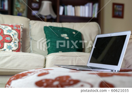 Laptop on a fabric top with couch on sight, a home Laptop on a fabric top with couch on sight, a home 60621035