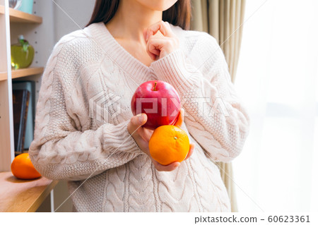Thinking of a pregnant woman with apple and tangerine Thinking of a pregnant woman with apple and tangerine 60623361