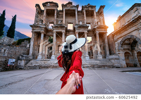 Women tourists holding man's hand and leading him to Celsus Library at Ephesus ancient city in Izmir 60625492