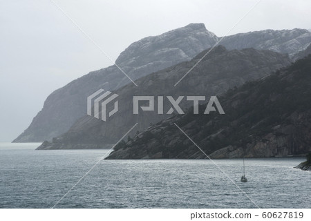 Sail Boat Navigating Through The Norwegian Fjords Sail Boat Navigating Through The Norwegian Fjords 60627819
