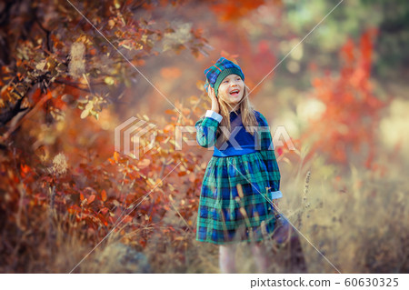 Baby girl dressed in the French style on the background of bright yellow leaves in autumn forest Baby girl dressed in the French style on the background of bright yellow leaves in autumn forest 60630325