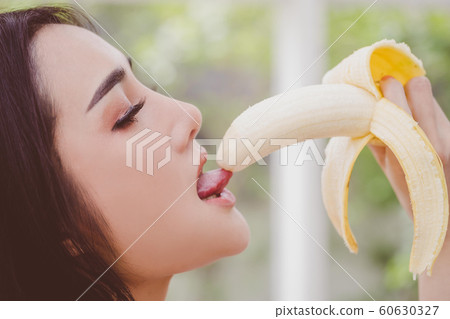 Asian woman is eating and licking the yellow 60630327