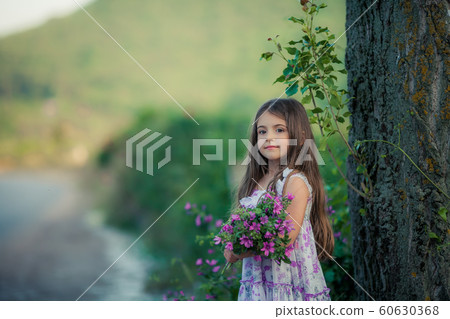 A child of 7-9 years collects a bouquet of wild flowers at outdoors A child of 7-9 years collects a bouquet of wild flowers at outdoors 60630368