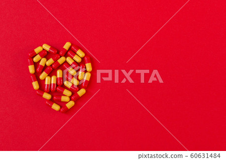 Red-orange pills in the shape of a heart Red-orange pills in the shape of a heart 60631484