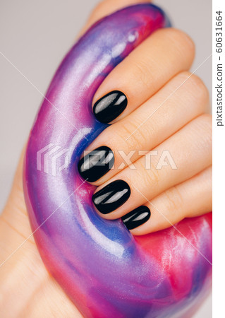 hands with black manicure holding slime hands with black manicure holding slime 60631664