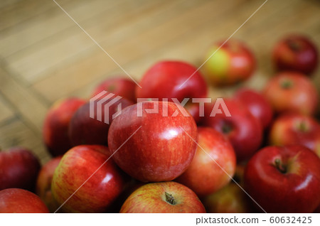 Sweet ripe red juicy apples on wooden background, healthy eating and vegetarian lifestyle concepts. Sweet ripe red juicy apples on wooden background, healthy eating and vegetarian lifestyle concepts. 60632425