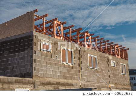 House under construction. Just after instalation of fibreboard on the roof. Wooden planks and pressed wooden OSB panels. 60633682