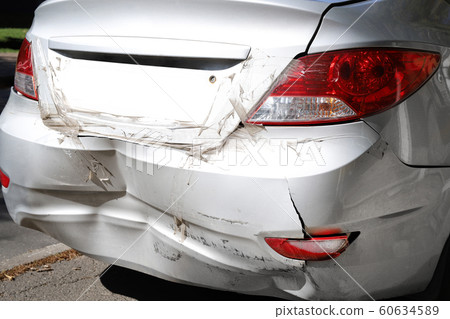 Close-up wrecked rear bumper and tail lights of new modern grey car after vehicle accident on road at bright sunny day Close-up wrecked rear bumper and tail lights of new modern grey car after vehicle accident on road at bright sunny day 60634589