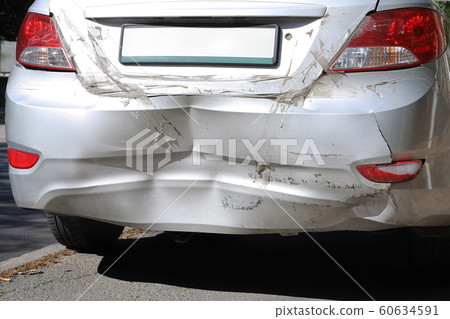 Close-up wrecked rear bumper and tail lights of new modern grey car after vehicle accident on road at bright sunny day Close-up wrecked rear bumper and tail lights of new modern grey car after vehicle accident on road at bright sunny day 60634591