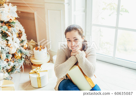 Young girl with gift box near Christmas tree on 60635087