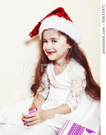little cute girl in santas red hat waiting for Christmas gifts. holiday lifestyle people concept little cute girl in santas red hat waiting for Christmas gifts. holiday lifestyle people concept 60635971