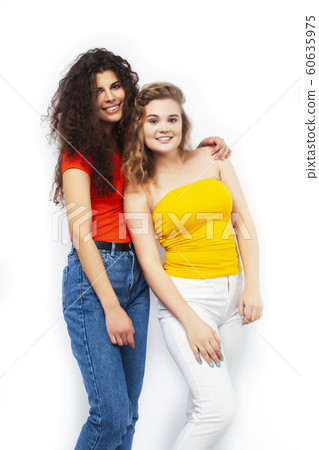 young pretty teenage girls friends with blond and brunette curly hairs posing cheerful isolated on white background, lifestyle people concept young pretty teenage girls friends with blond and brunette curly hairs posing cheerful isolated on white background, lifestyle people concept 60635975
