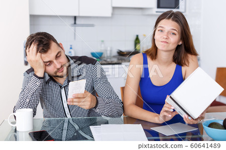 Upset young couple with financial bills and box having conflict 60641489
