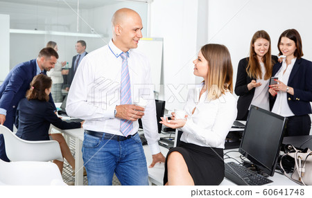 Group of happy business people chatting while enjoying coffee break in coworking space Group of happy business people chatting while enjoying coffee break in coworking space 60641748